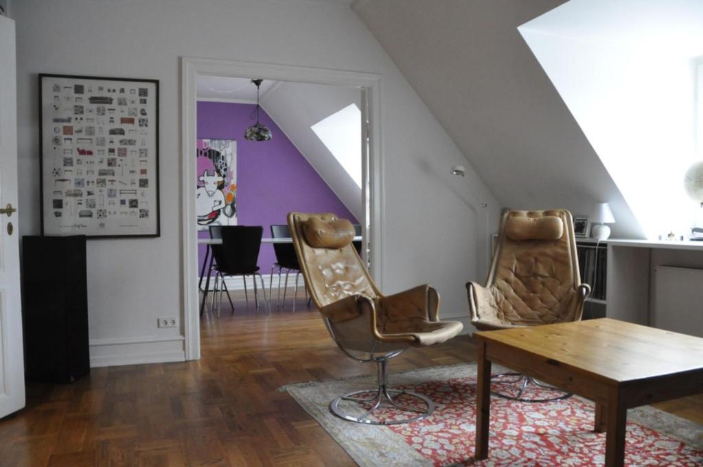 哥本哈根哥本哈根公寓469的客厅配有两把椅子和一张桌子