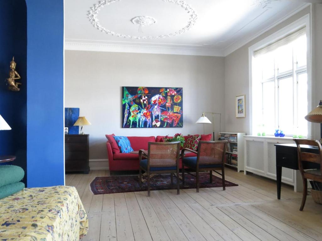哥本哈根哥本哈根1150公寓的客厅配有红色的沙发和椅子