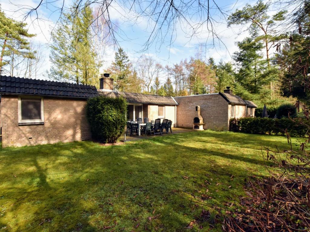 洛赫姆Appealing Holiday Home in Guelders near Forest的砖屋,有草地庭院的泥砖