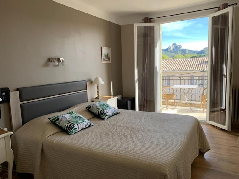 圣雷米普罗旺斯科斯特艾尔皮酒店的一间卧室配有一张带两个枕头的床