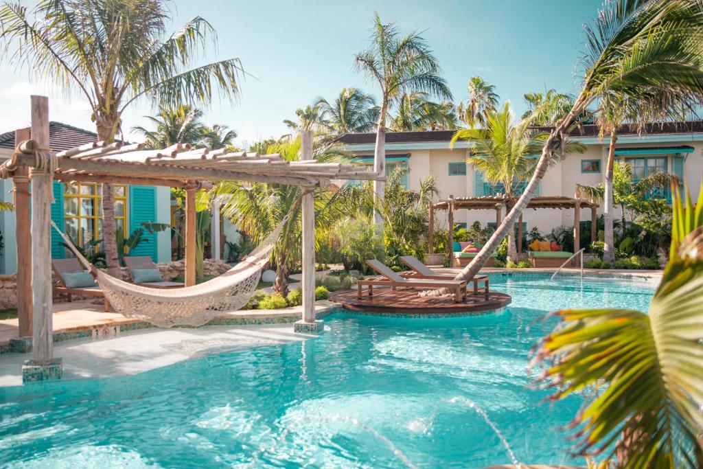 棕榈滩Boardwalk Boutique Hotel Aruba - Adults Only的一个带吊床的游泳池和一个度假村