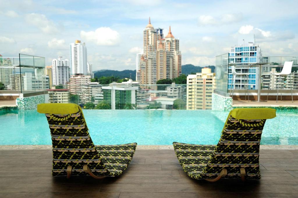 巴拿马城巴拿马禅贝斯特韦斯特酒店的两把椅子坐在一个享有城市美景的阳台上