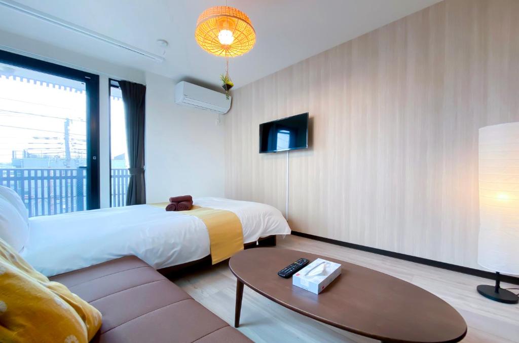 东京japan house sky tree的酒店客房,配有床和沙发