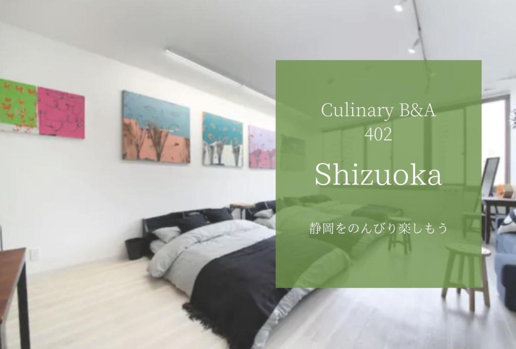 滨松Culinary Bed&Art 402的卧室配有一张床,墙上挂有绘画作品