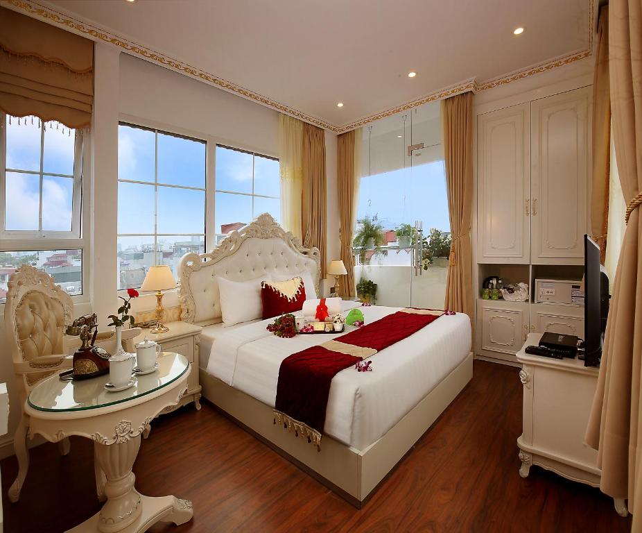 河内Hanoi Hotel Royal的卧室配有白色的床、桌子和窗户。