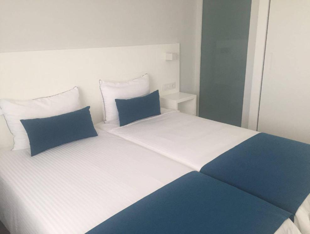 波多黎各Puerto Príncipe的一张白色和蓝色的床,上面有蓝色的枕头