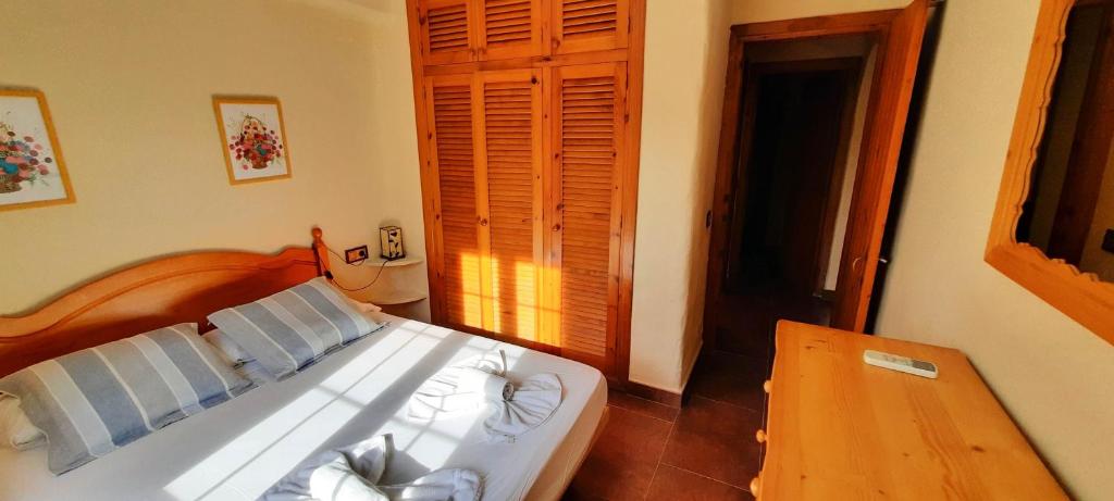 福尔内利斯Homenfun Menorca Playa de Fornells I的卧室配有白色的床和木桌
