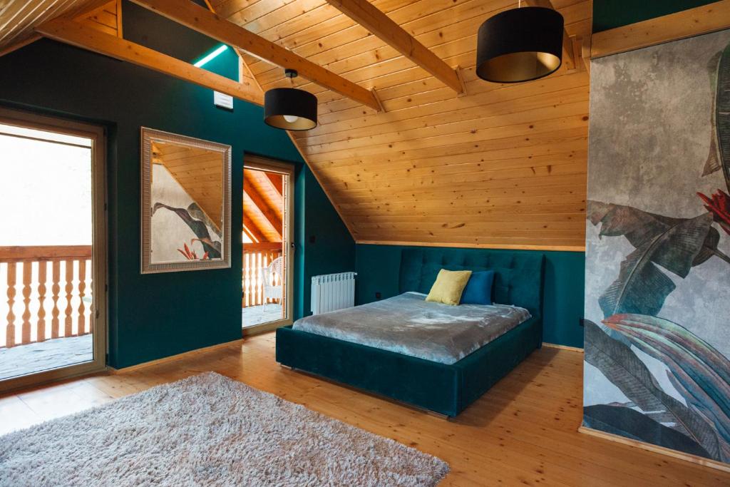 拉伊恰Domek Przy Strumyku的一间带一张床的卧室,位于带木制天花板的房间内