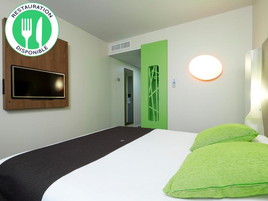 里尔里尔欧洲里尔钟楼酒店的卧室配有一张床铺,墙上配有电视