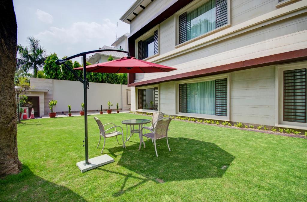 新德里La Sagrita的庭院配有桌椅和遮阳伞。