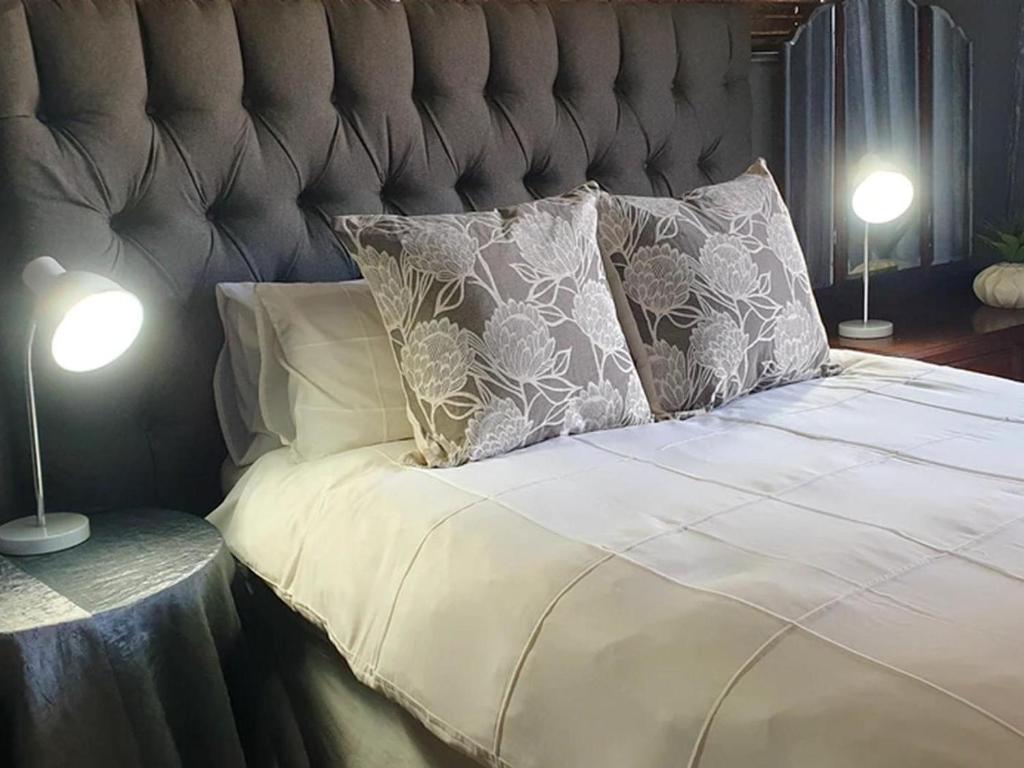CarolinaRand Self-catering Accommodation的一张带两个枕头的床和两盏灯