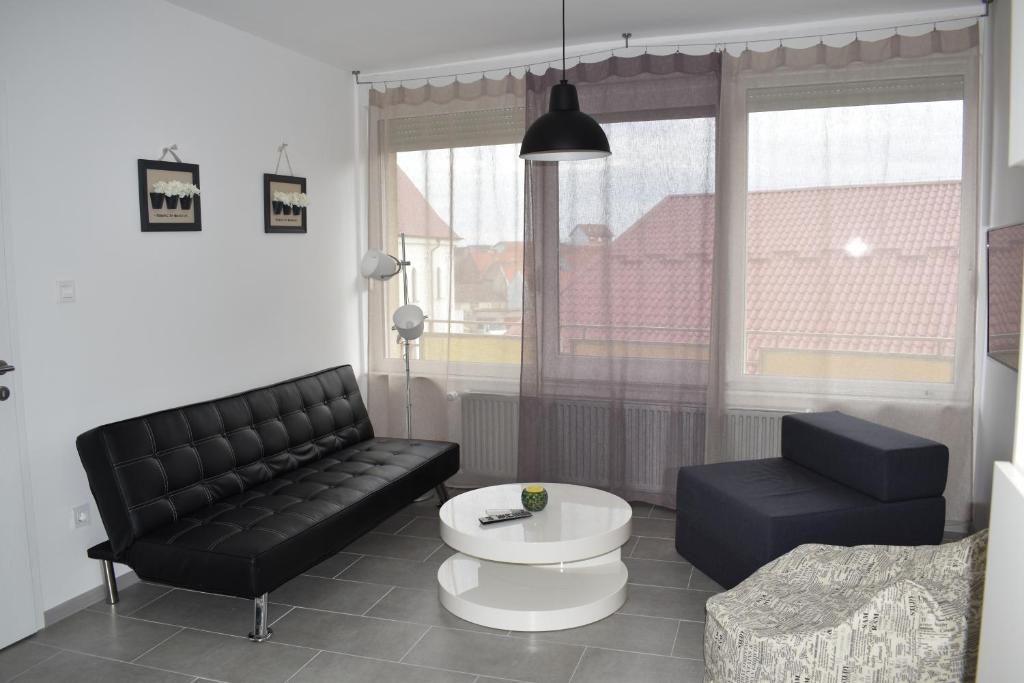 武科瓦尔Apartman WALKOW的客厅配有黑色沙发和桌子