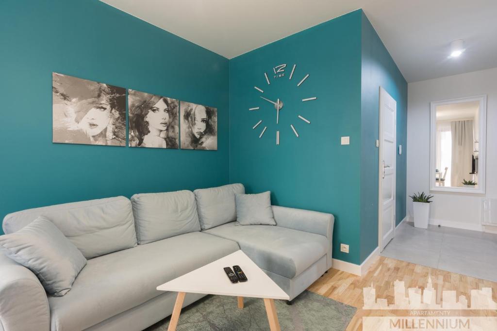 华沙Millennium Awangarda Mint的客厅配有沙发和墙上的时钟