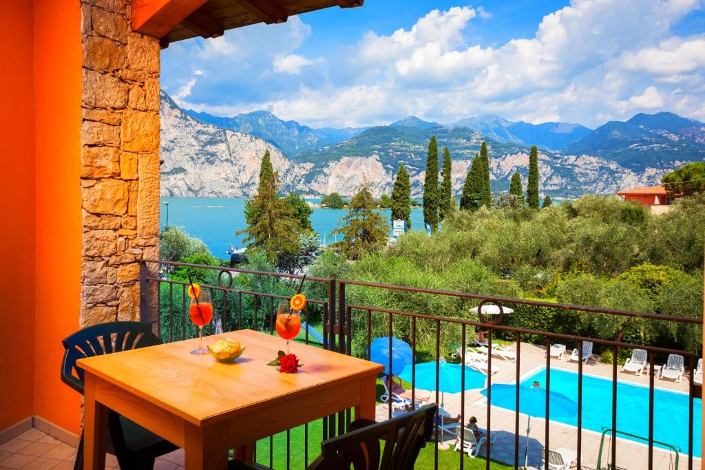 布雷佐内加尔达Hotel Villa Isabella的阳台配有桌子,享有游泳池的景色