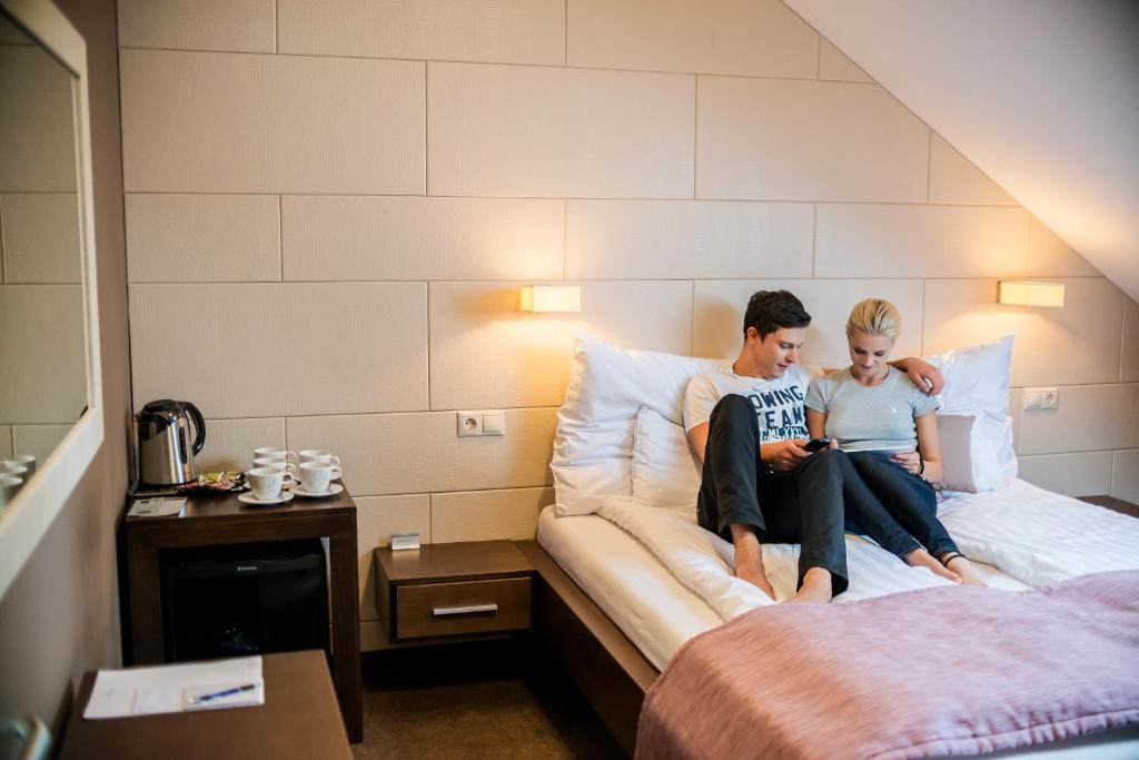 尼赖吉哈佐福尔多哈兹酒店的两人坐在酒店房间的床边