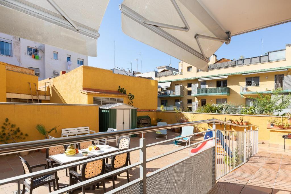 巴塞罗那巴塞罗那度假露台公寓的大楼内的阳台配有桌椅