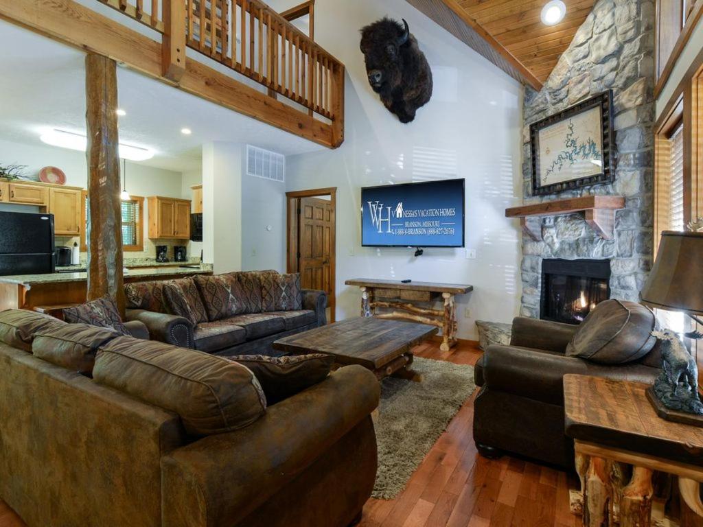 布兰森Lodge 243的客厅配有皮革家具和石制壁炉