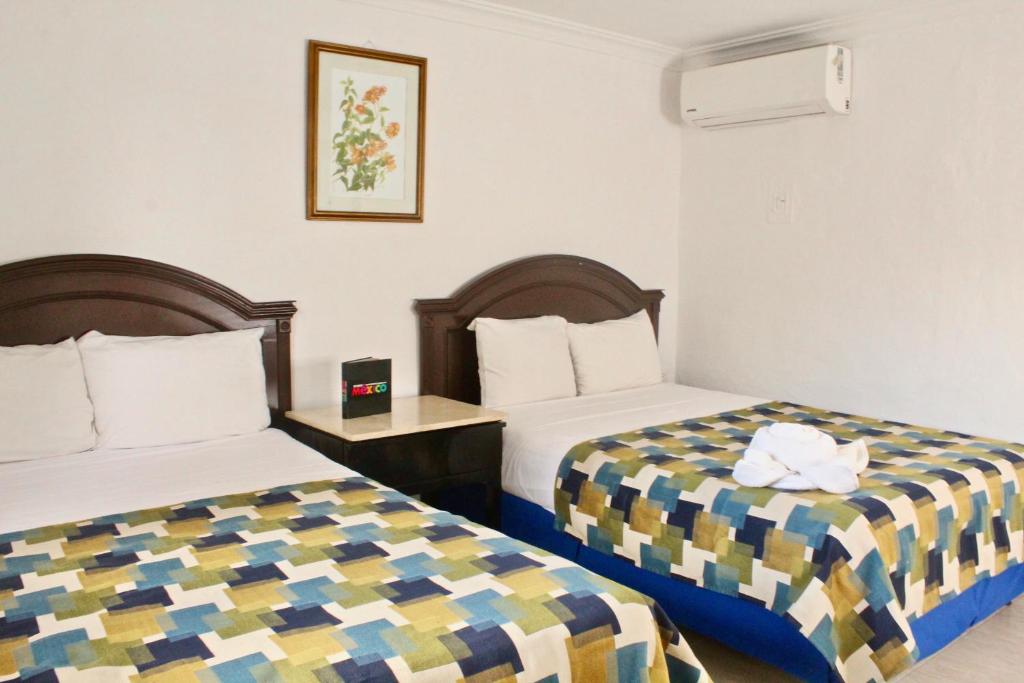 梅里达埃尔熙德酒店的一间酒店客房,房间内设有两张床