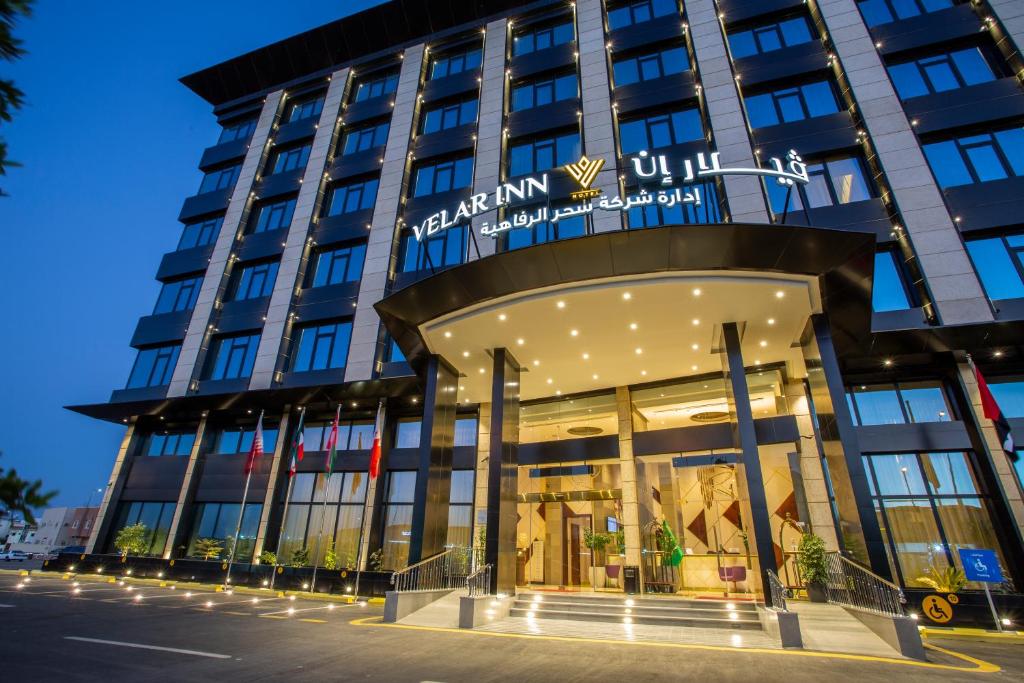 塔伊夫Velar Inn Hotel的夜间在建筑物前的商店