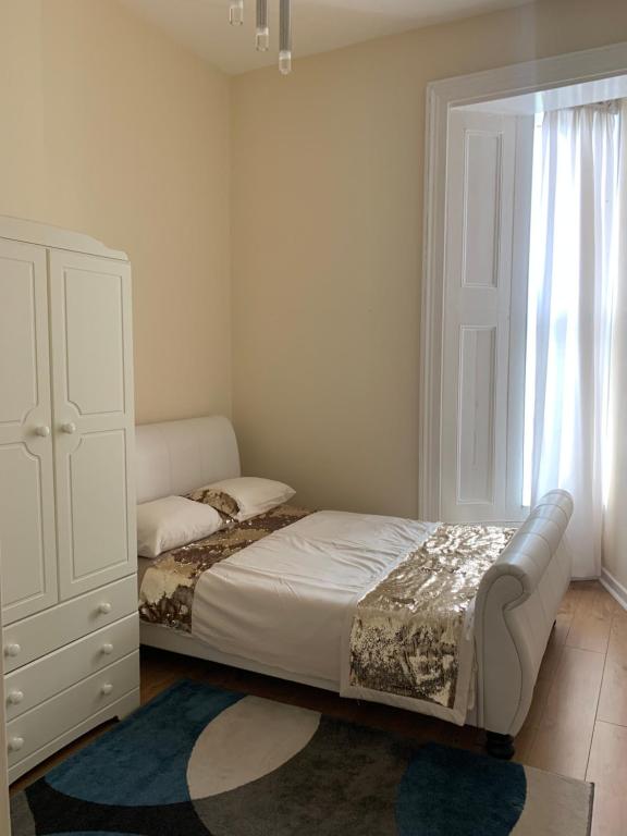 赖德WIGHTHOLIDAY的一间卧室配有一张床、一个梳妆台和一扇窗户。