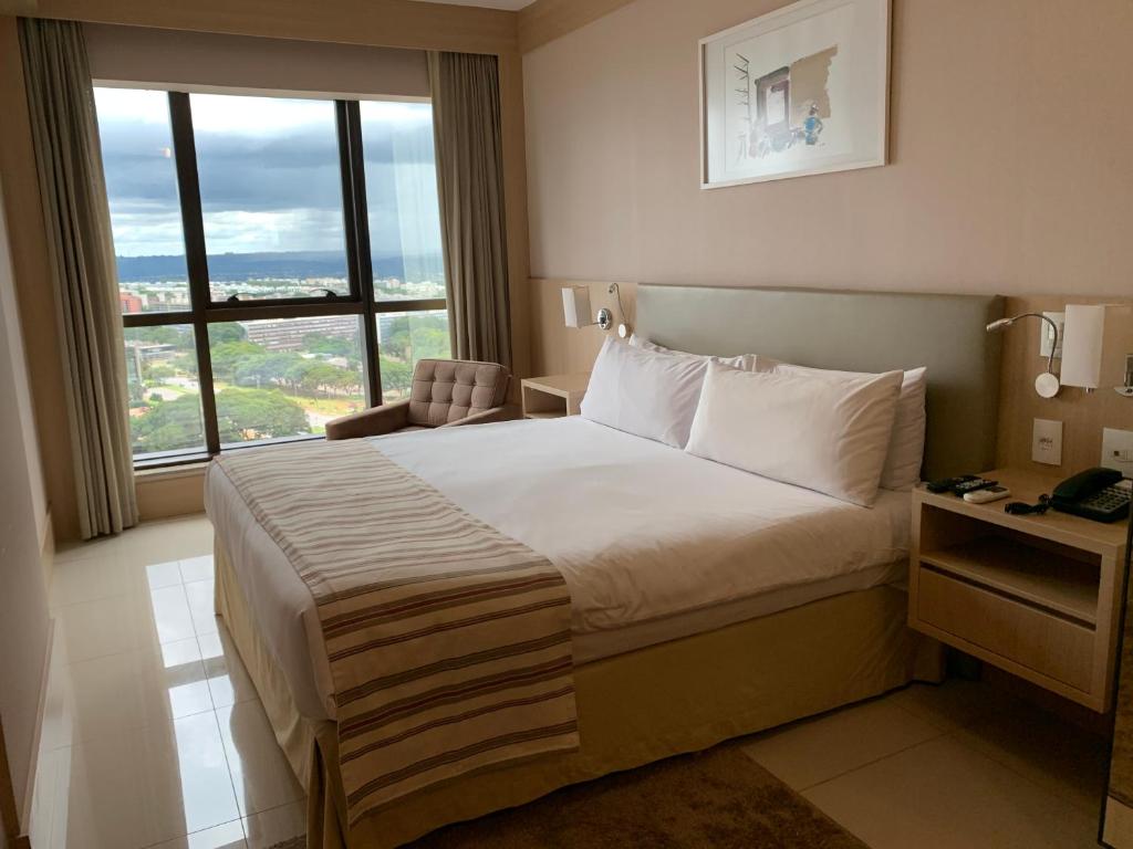巴西利亚Localização incrível vista ótima equipado e novo的酒店客房设有一张床和一个大窗户