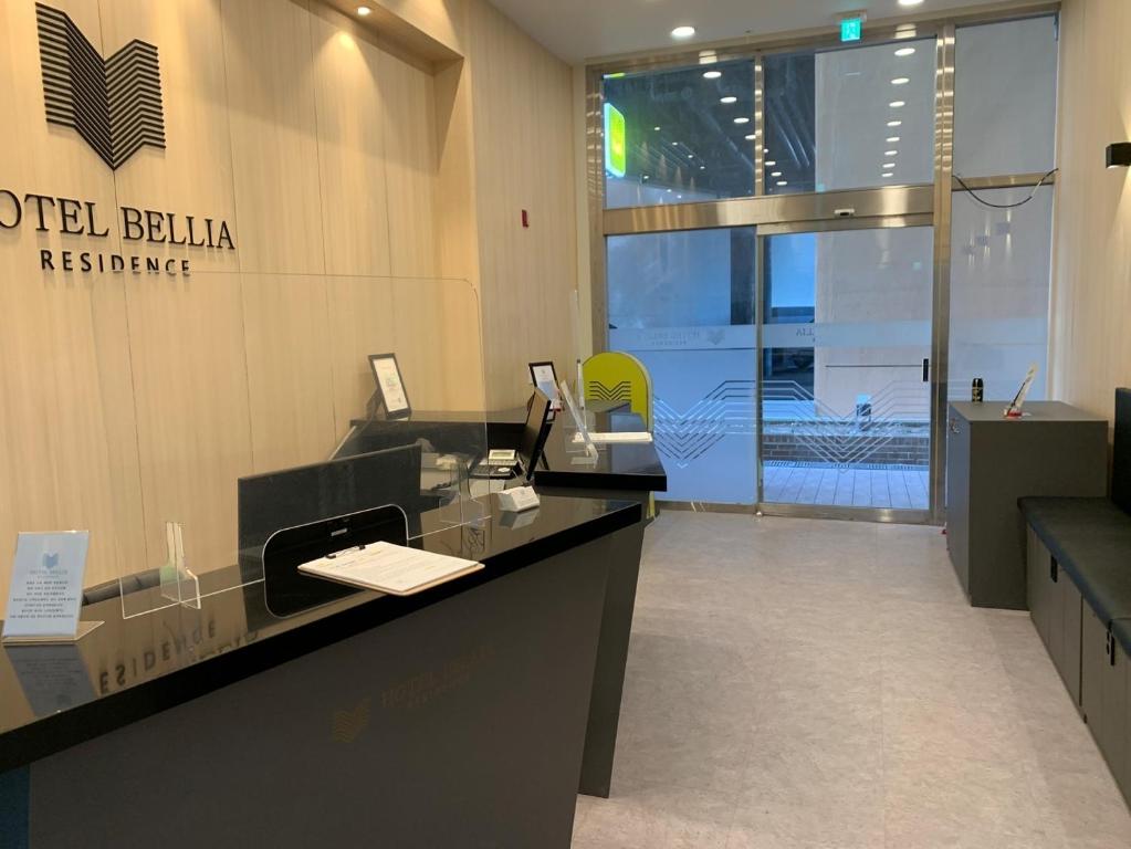 釜山Hotel Bellia的办公室,设有前台,墙上有标志