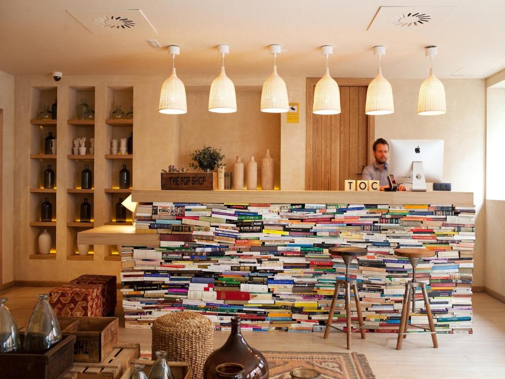塞维利亚塞维利亚TOC旅馆的一个人站在一大堆书后面
