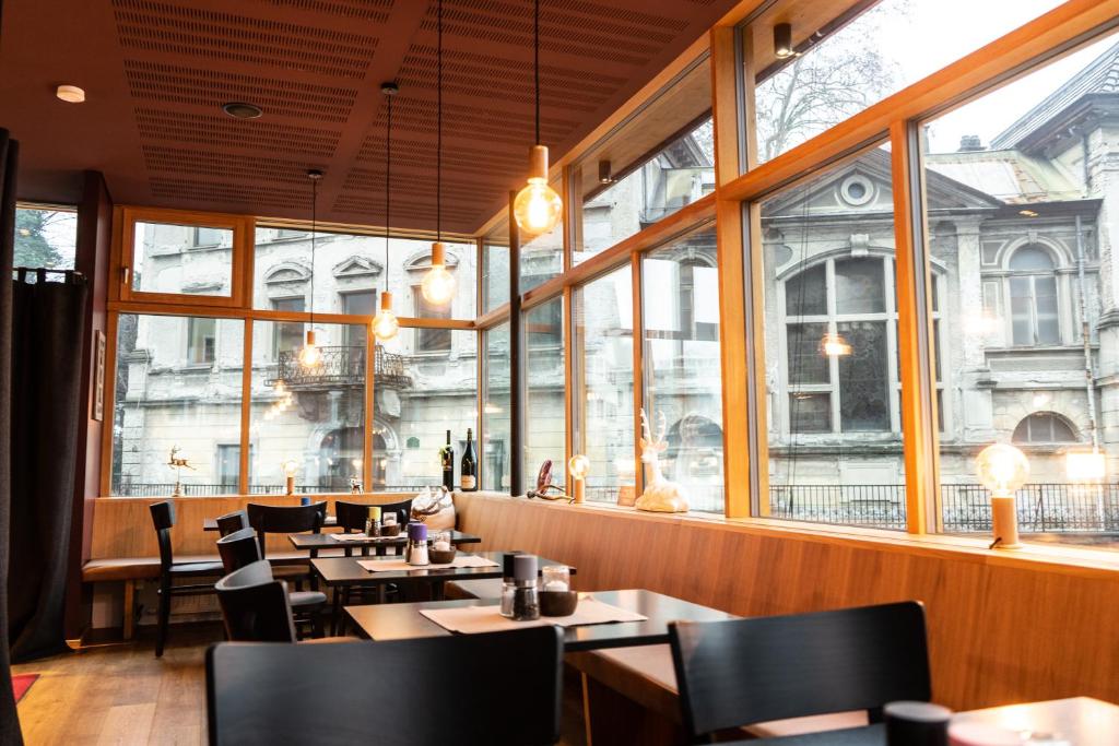 霍恩埃姆斯Landgasthof Hirschen的餐厅设有桌椅和大窗户。
