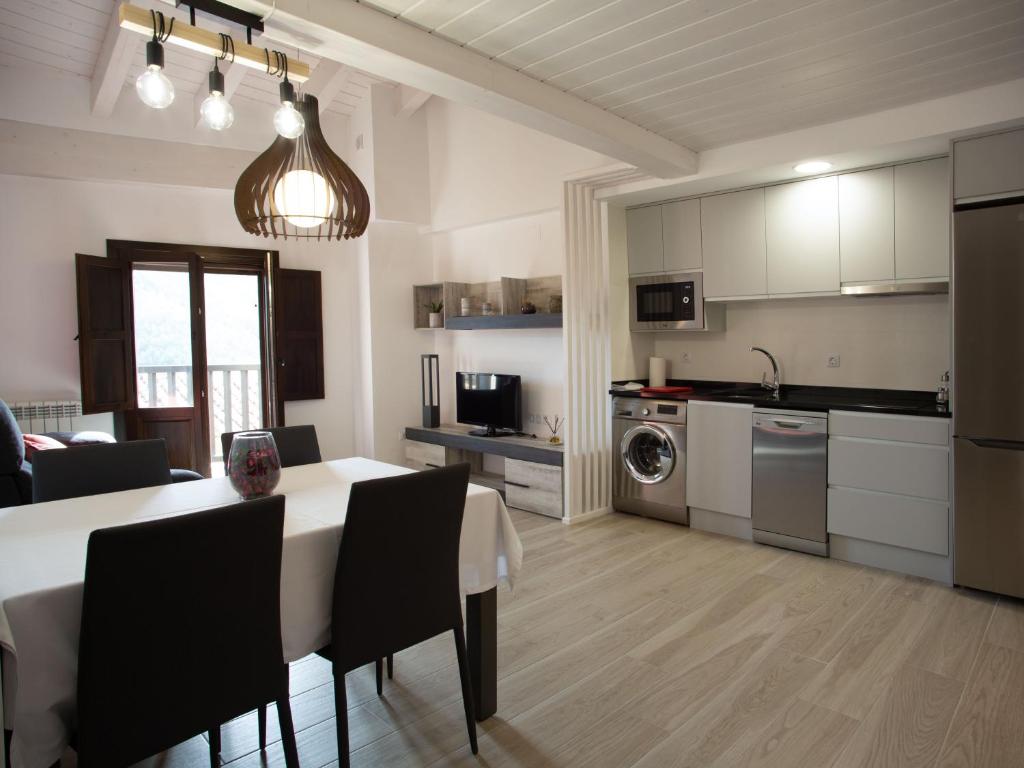 阿尔巴拉辛Apartamento Subida Las Torres的厨房以及带桌椅的起居室。