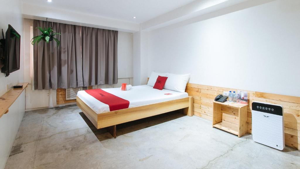 马尼拉红门优质酒店 @ 邦尼大道曼达鲁永的一间卧室配有一张床和一台电视。