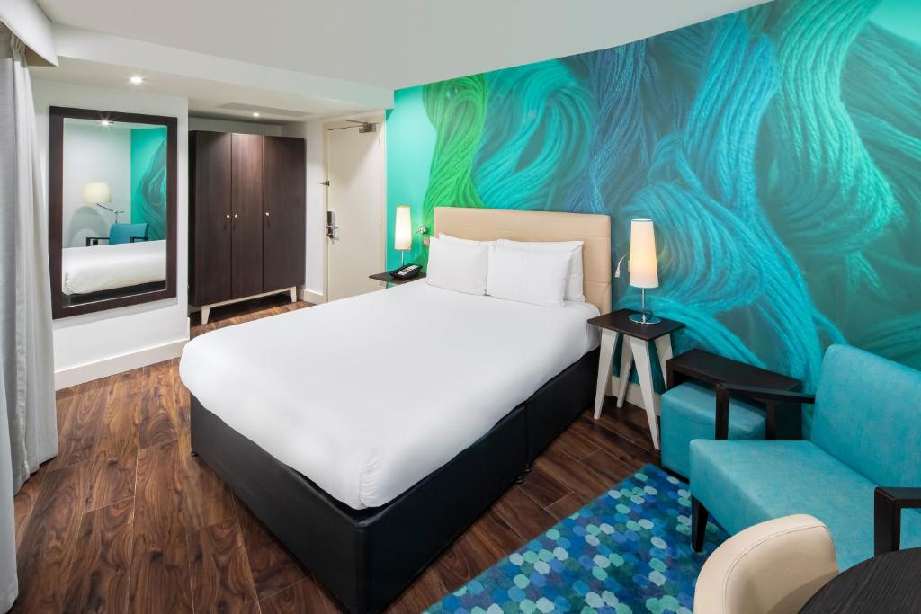 利物浦靛蓝利物浦酒店的酒店客房,配有床和蓝色的沙发