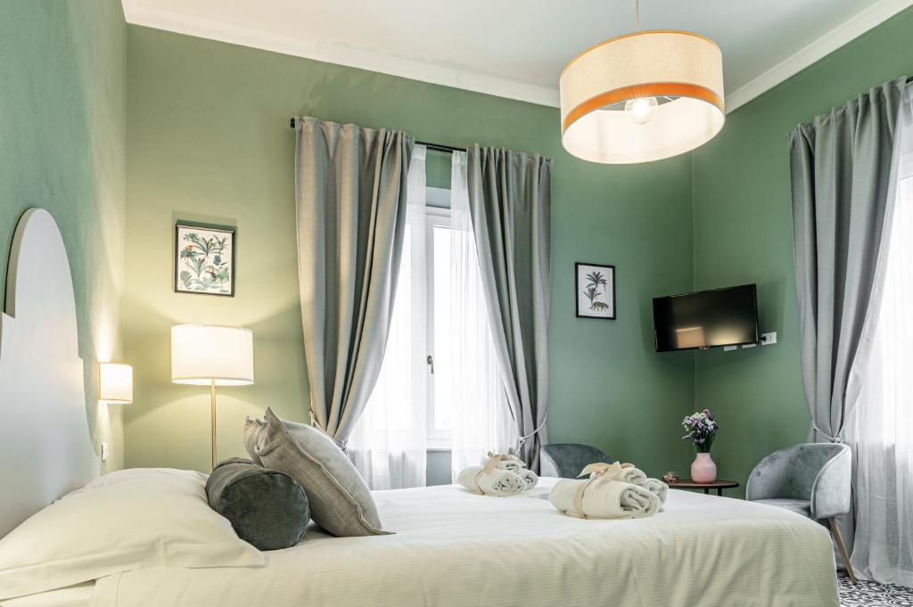比萨La Lu cozy rooms 2 - Self check-in的一间卧室设有一张带绿色墙壁的大床