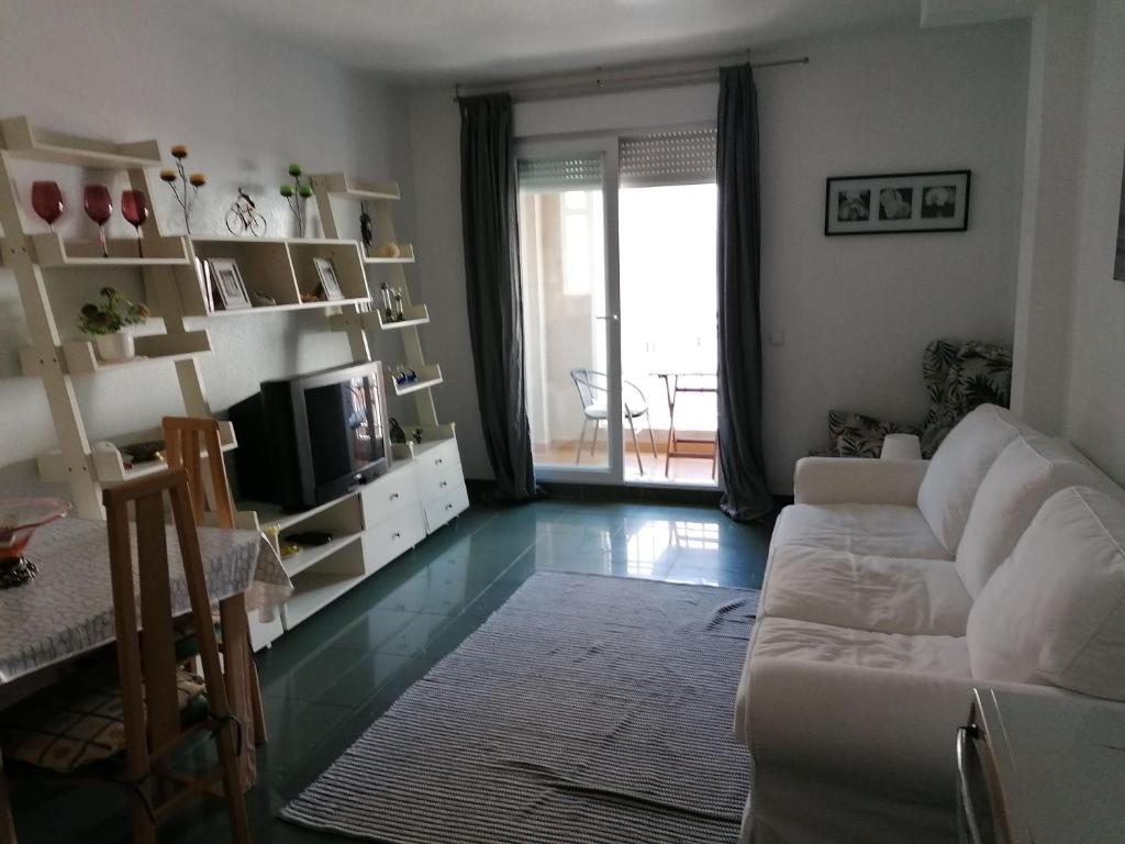 滨海罗克塔斯Apartamento ROQUETAS DE MAR MUY CERCA PLAYA的客厅配有白色沙发和电视