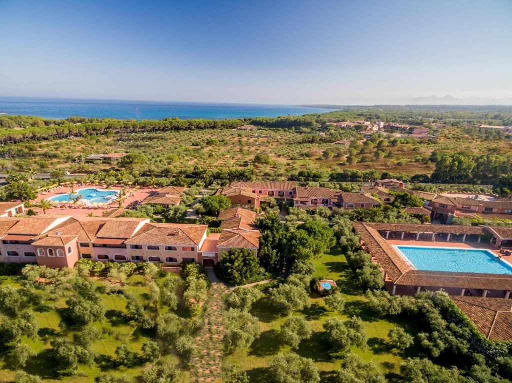 卡拉·利贝罗托I Giardini di Cala Ginepro Hotel Resort的享有带游泳池的度假村的空中景致