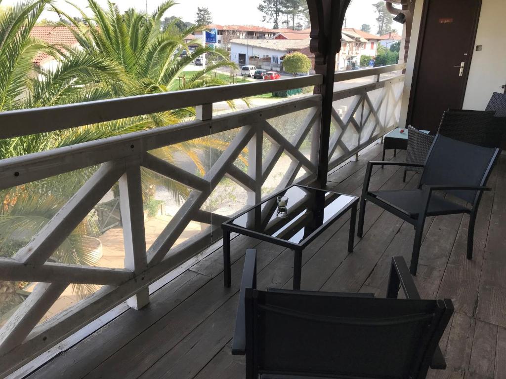 塞尼奥斯Hôtel La Cote d'Argent的阳台配有椅子,享有棕榈树的景致。