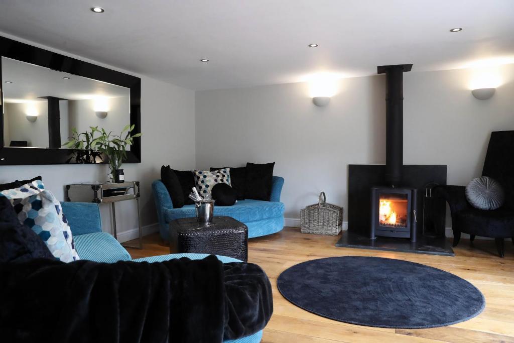 阿伯加文尼Pen-Y-Worlod Cottages的客厅设有蓝色的沙发和壁炉