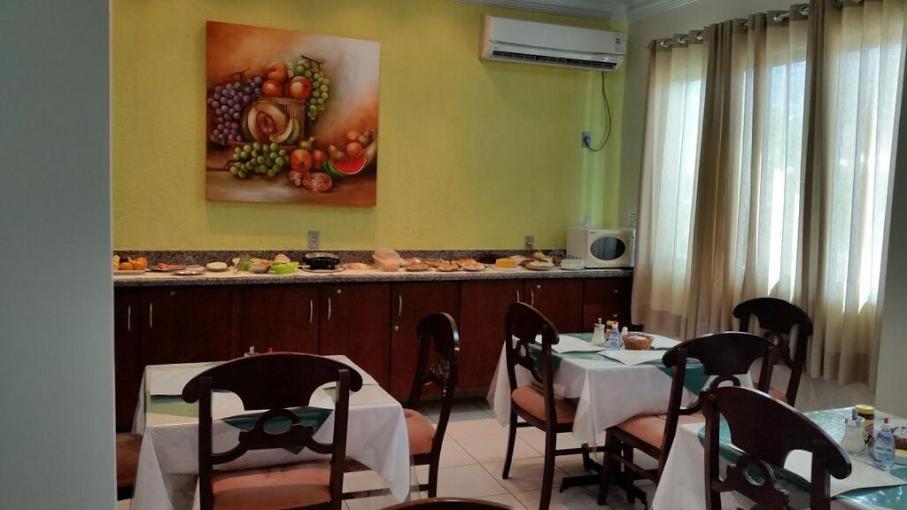 帕尔马斯Hotel Graciosa Palace的一间带桌椅的用餐室,并画有水果