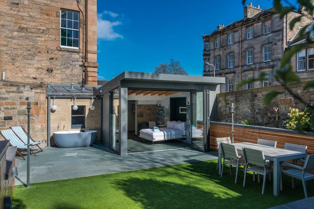 爱丁堡Garden Rooms Edinburgh的庭院内带床和浴缸的凉亭