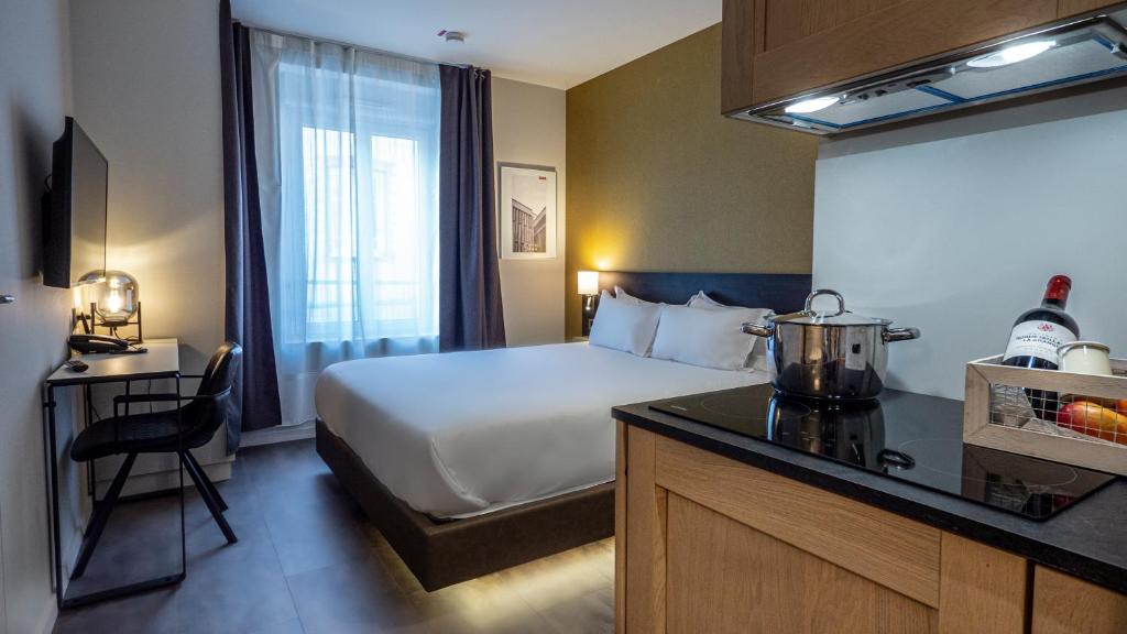 绍莱Five Resort Cholet Centre的酒店客房带一张床和一个厨房