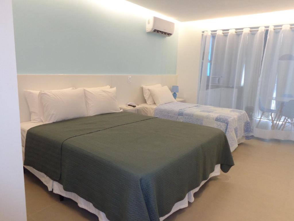 巴西利亚HOTEL GARVEY Quarto 321的酒店客房设有两张床和窗户。