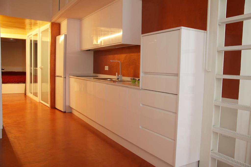 普里埃格·德·科尔多巴Casa Rural Torrejón XV的厨房铺有木地板,配有白色橱柜。