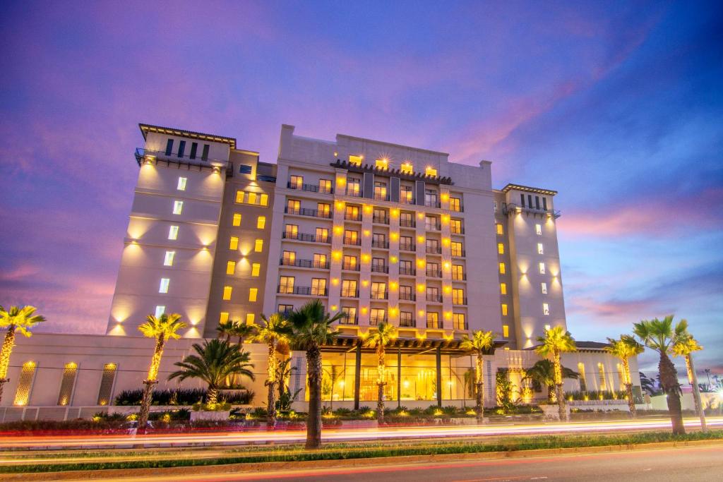 恩塞纳达港Torre Lucerna Hotel Ensenada的一座棕榈树环绕的大建筑