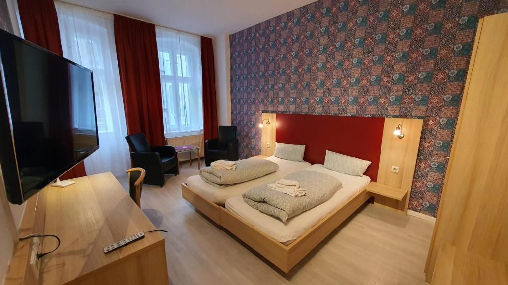 柏林伯恩霍尔默霍夫普伦茨劳贝格酒店的一间卧室配有一张床和一台平面电视