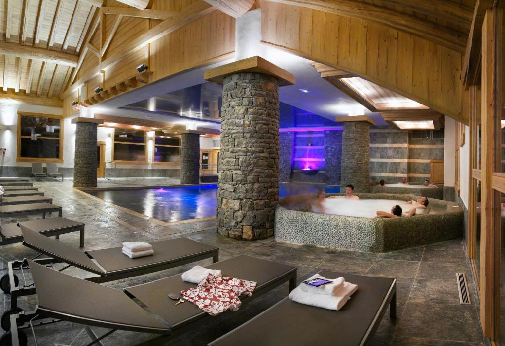 拉普拉涅CGH公寓酒店&莱斯格兰吉斯都苏利Spas的酒店大堂设有热水浴缸,其中两人使用
