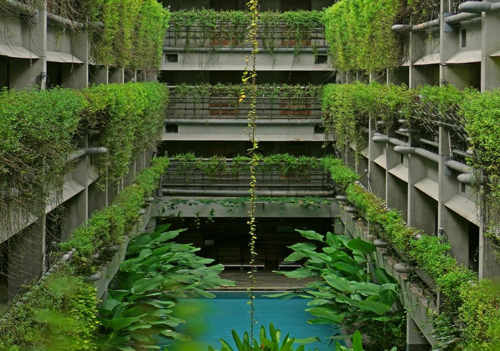 日惹普拉维塔玛格林霍斯特精品酒店的一座拥有水和植物的建筑