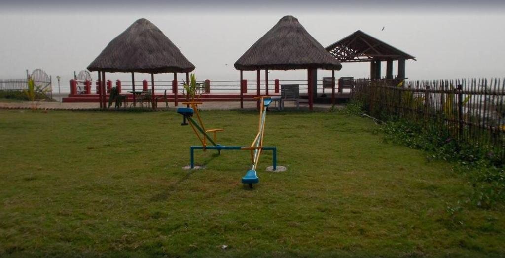 曼达莫尼Arya Beach resort的草地上有两个游戏设备的公园