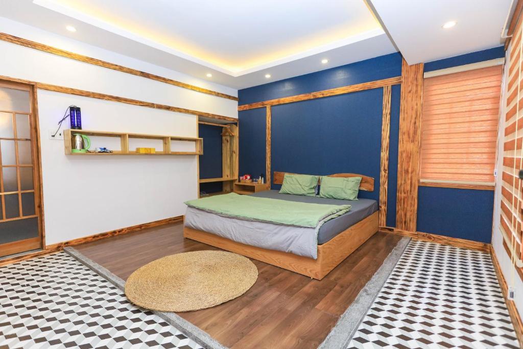 归仁Japan Homestay Quy Nhon的一间卧室设有一张床和蓝色的墙壁