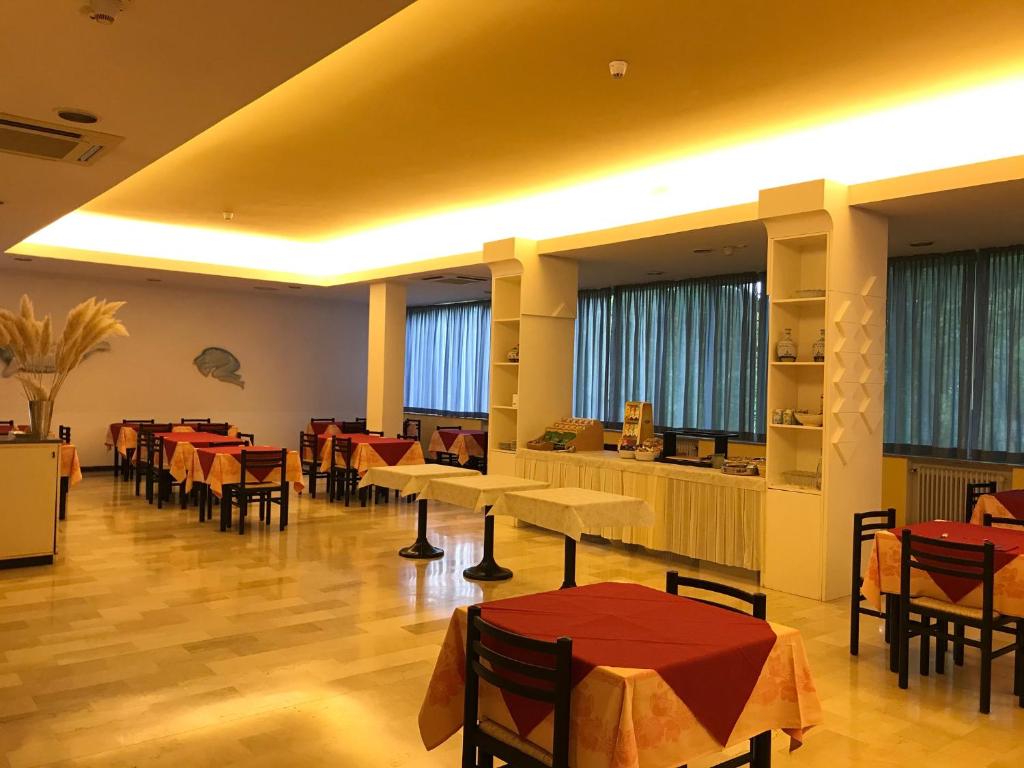 廖洛泰尔梅希尼欧酒店的餐厅设有桌椅和窗户。