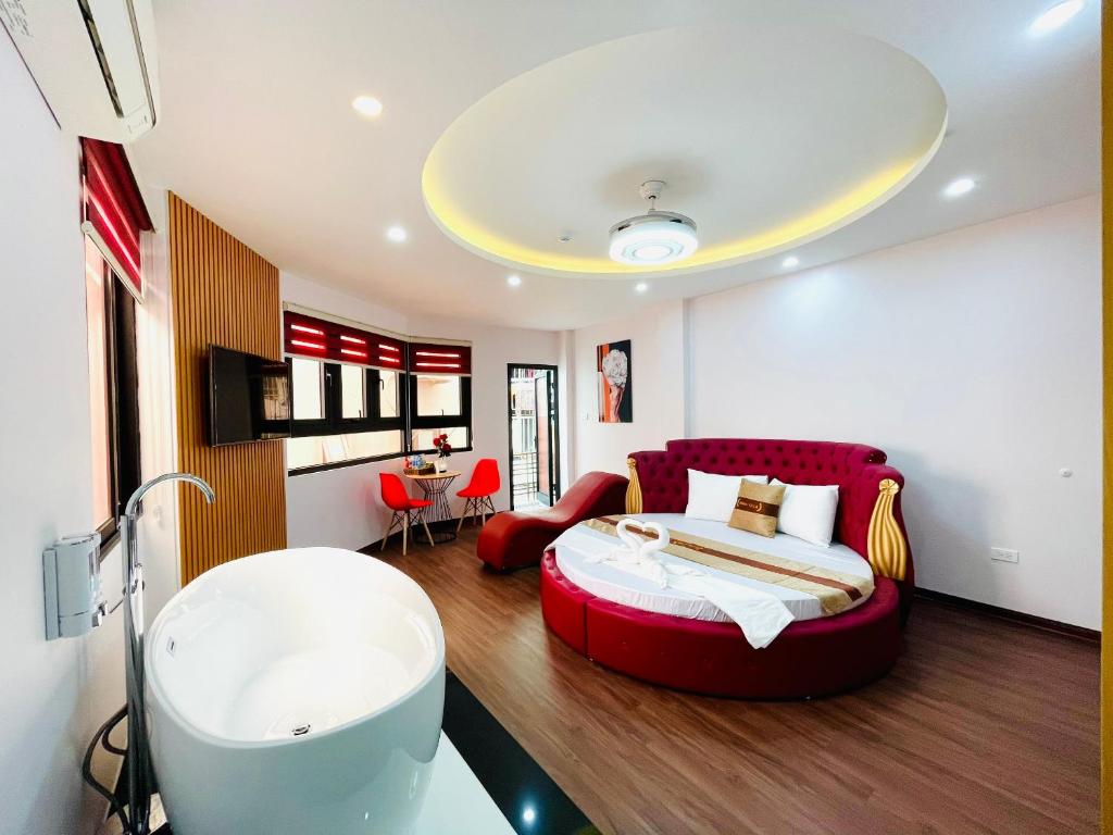 河内A&EM VILLA的一间卧室设有一张红色大床和一个浴缸