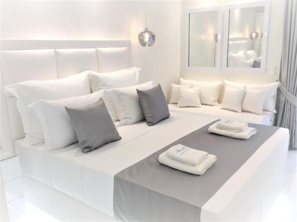 帕拉塔蒙Amaryllis Luxury Rooms的白色客房,床上配有两个白色枕头